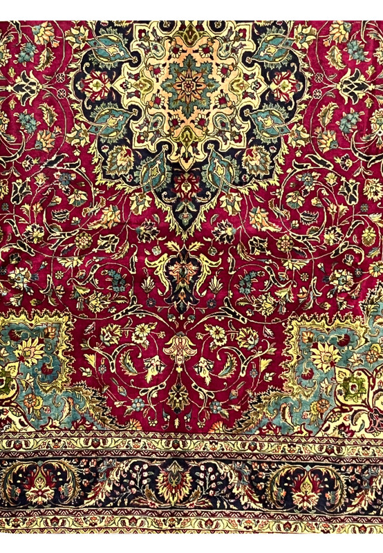 lower section of Persian Tabriz rug showing floral layout, rich red field, and multi-toned corner design