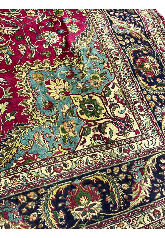 Detailed corner view of the 9'9 x 12'4 vintage Persian Tabriz rug showing turquoise corner spandrel, floral motifs, and navy border with fine wool pile.