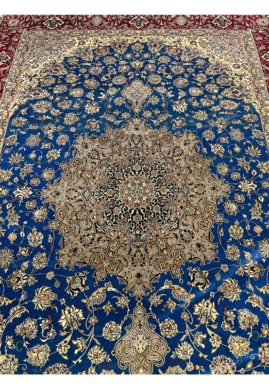Detailed midfield view highlighting the blue background, floral motifs, and intricate medallion of the Persian Isfahan wool and silk rug.
