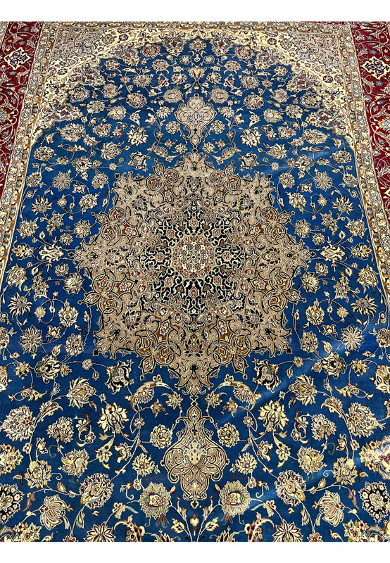 Close-up of the ornate Persian Isfahan medallion with cream, beige, and silk-accent detailing set against a blue floral field.