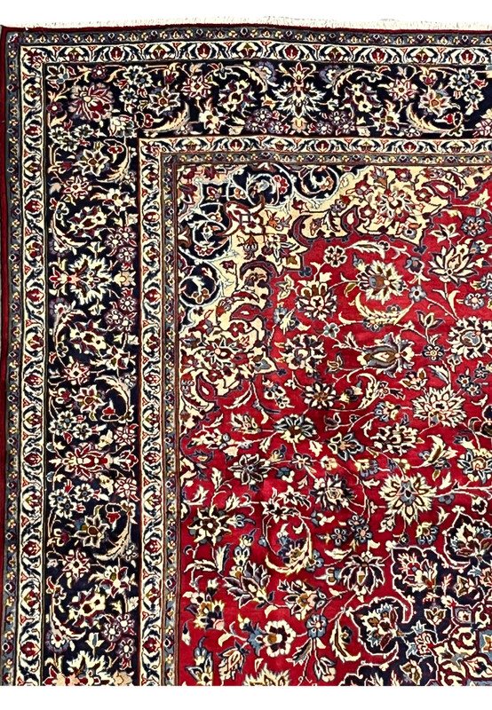 Persian Isfahan rug upper border close-up with navy floral bands and ivory accents
