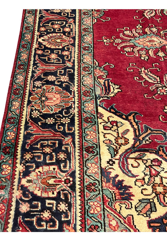 Side angle of the 10x13 Vintage Tabriz Rug showing low pile, patina marks, and floral structure.