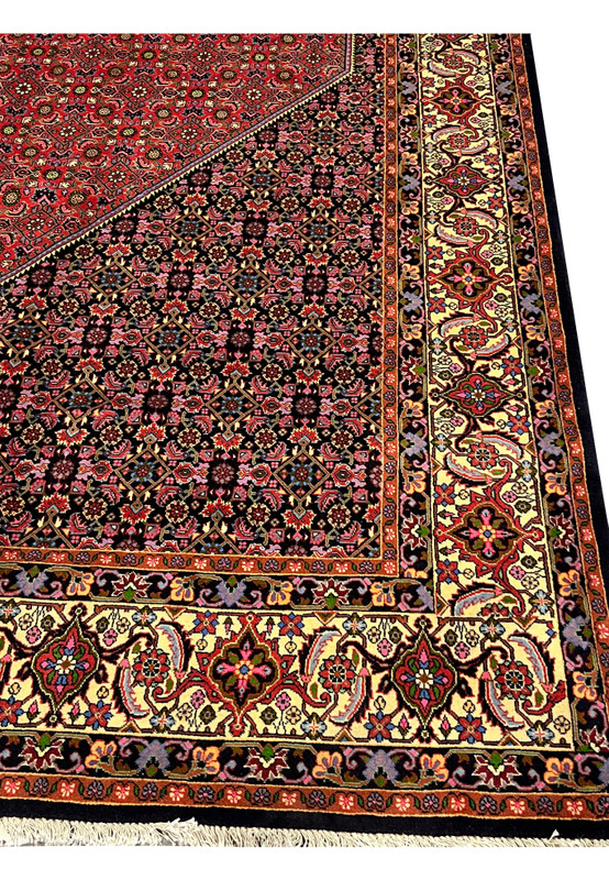 Wide outer border of Persian Bijar rug with flowing floral vines, palmettes, ivory ground, and navy protective frame