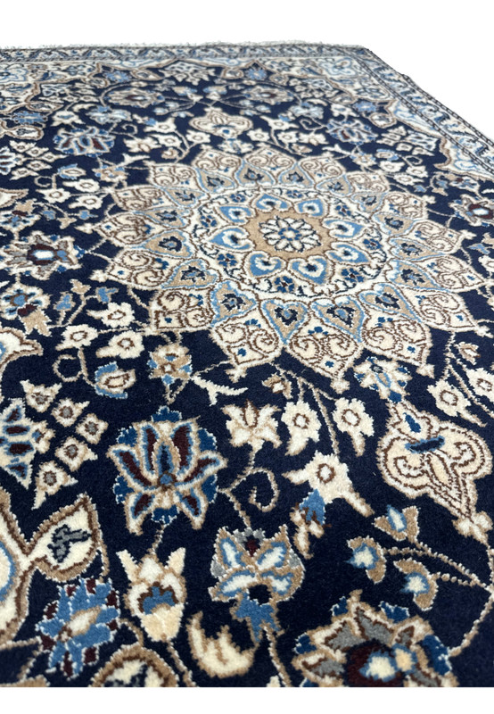Angled perspective of 3x5 Persian Nain rug showing navy blue pile depth, ivory medallion contrast, and fine floral weaving