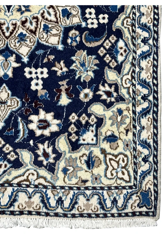 Beige and ivory border with navy and sky blue floral design on Persian Nain rug