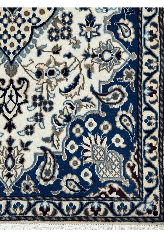 Border detail of Persian Nain rug with royal navy blue background, ivory floral motifs, powder blue accents, and scrolling vine patterns