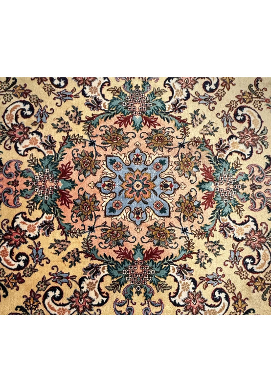 Close up of coral and slate blue central medallion with ivory and charcoal detailing on Persian Tabriz rug