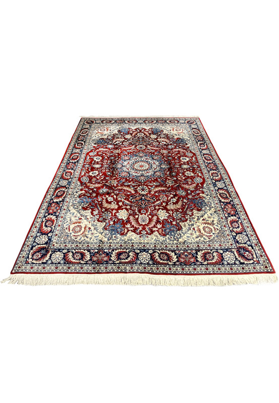 Laid down 8'5 x 11'8 floral Persian Isfahan rug with deep red field, intricate ivory floral vines, and classic navy border
