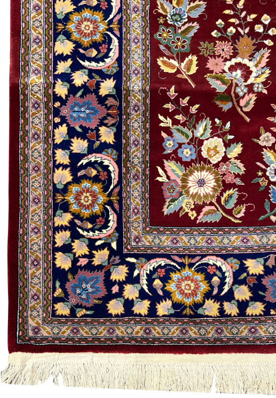 Side border view of Persian Isfahan rug showing navy background and floral medallions