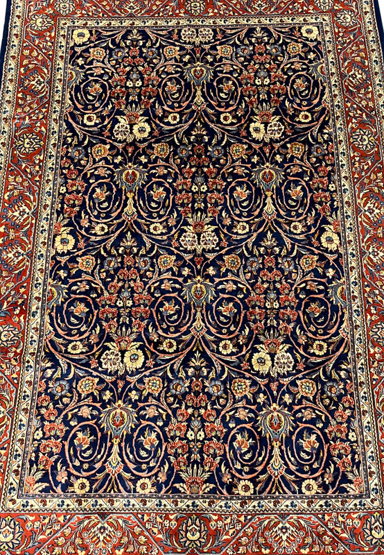 Close view of navy field with intricate floral vines on a Persian Sarough rug