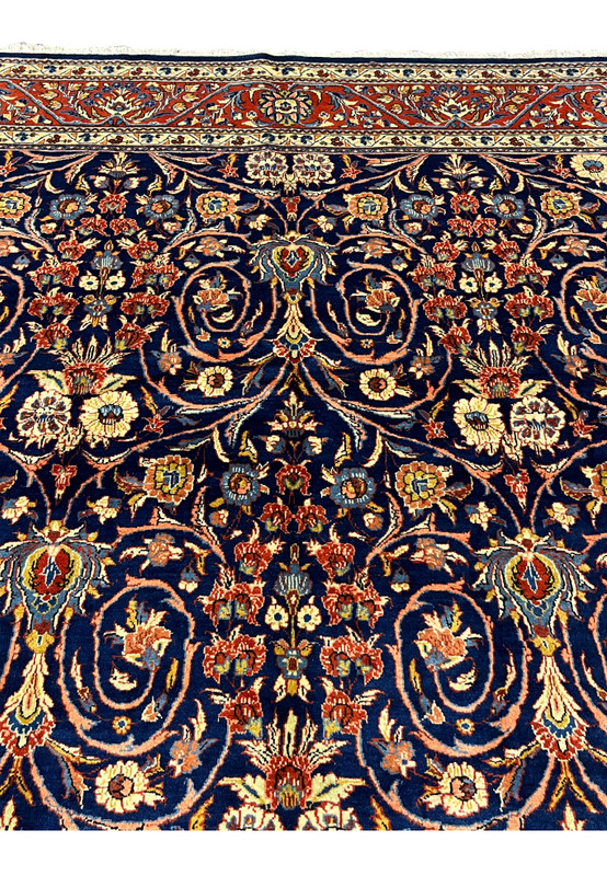 Upper border detail of Persian Sarough rug with red ground, ivory accents, and traditional floral patterns