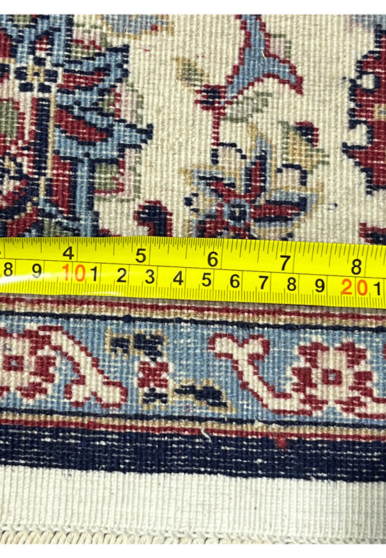 Backside of a navy blue Persian Sarough kork rug with measuring ruler showing precise weave density and straight selvedge alignment