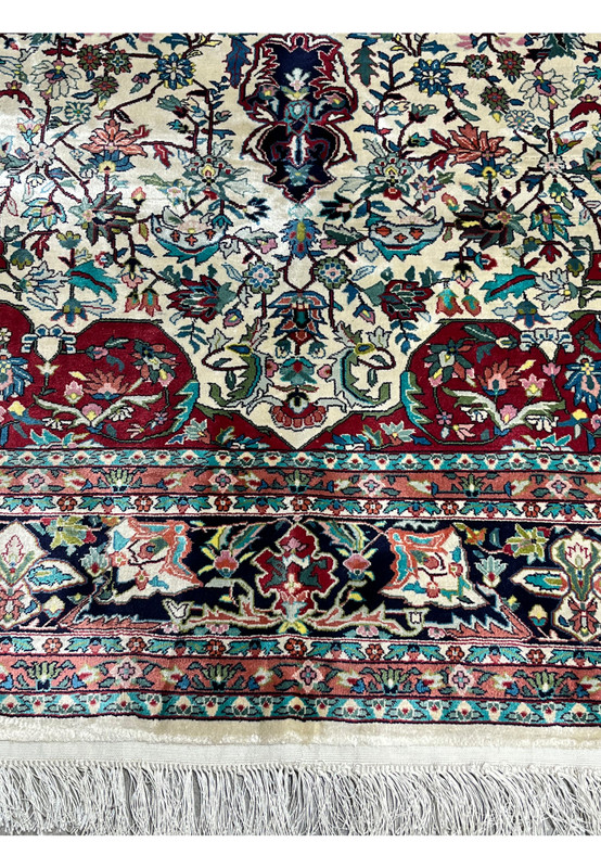 Lower border detail of silk oriental rug with floral motifs and rich colors