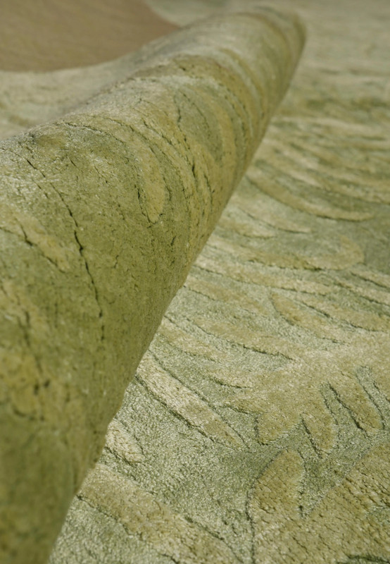 Folded corner image displaying the plush texture and layered green tones created by wool and silk fibers.