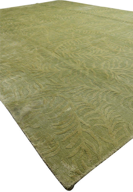 Angled perspective showing the sculpted surface and natural sheen of a modern olive and sage green wool and silk rug.