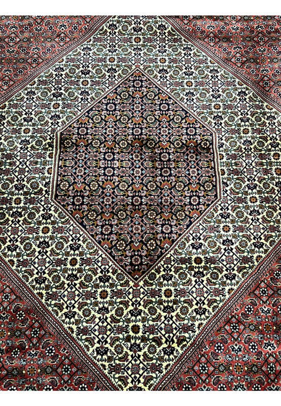 Detailed view of the central diamond medallion in a Persian Bijar iron rug with ivory ground and geometric patterning
