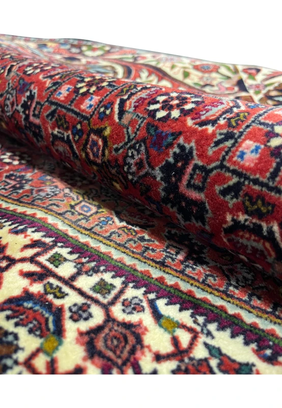 Texture detail of a rolled Persian Bijar rug showing dense wool pile and compact construction