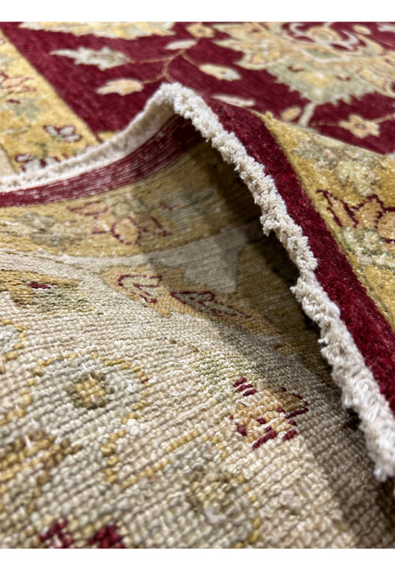 Backside closeup of a 12x15 Oriental Zigler Chobi Peshawar rug showing tight hand woven foundation and muted tones that appear warmer due to lighting