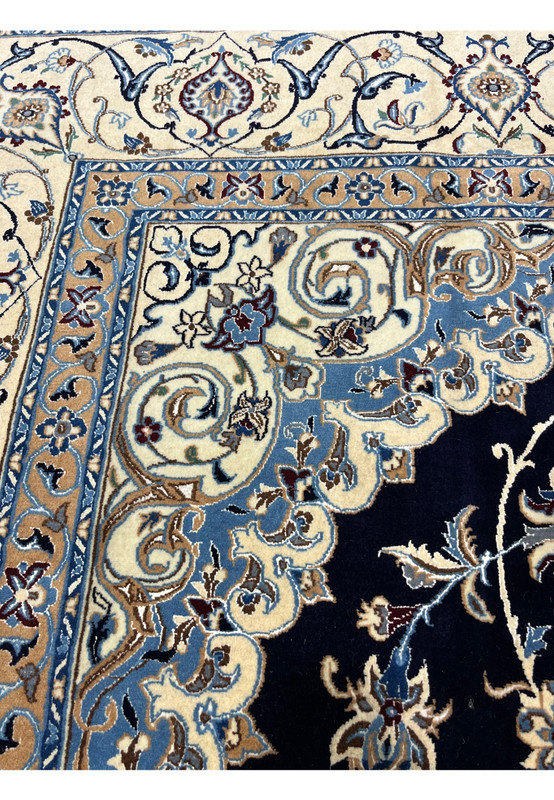 Inner border detail of Persian Nain silk rug displaying light blue vines, ivory ground, and tightly woven floral patterns with crisp definition