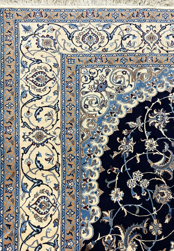 Close-up of ivory border on Persian Nain 6 LA rug showing repeating floral cartouches, fine outlines, and precise hand knotted structure