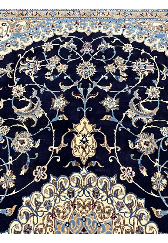Upper section of a 6'5 x 10 Persian Nain 6 LA rug showing midnight navy field with ivory floral vines, silk highlights, and finely detailed curvilinear motifs