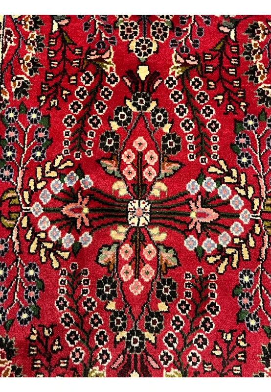 Central medallion detail of a Persian Darjazin rug featuring layered floral rosettes, mirrored symmetry, ivory accents, and precise village knot articulation