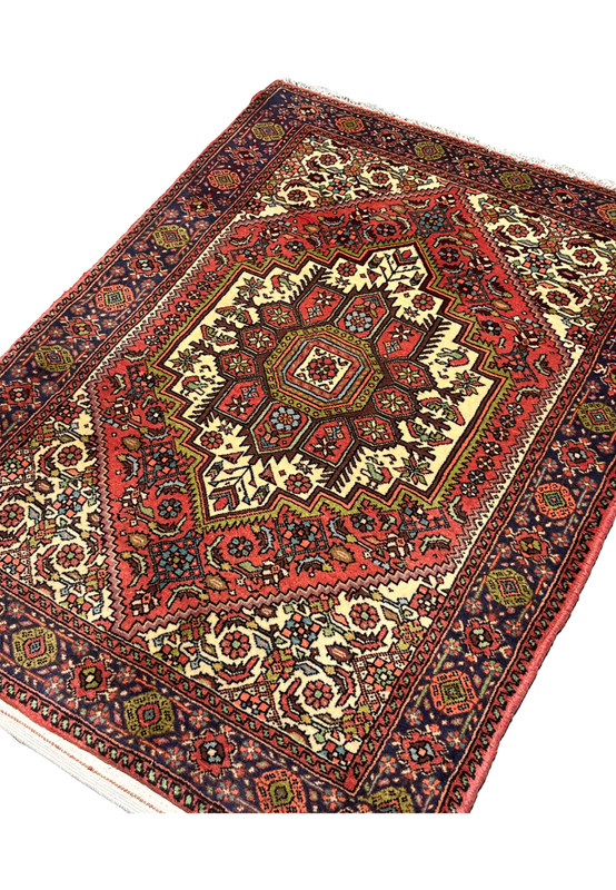 Angled perspective of Persian Gholtogh rug showing depth, bold geometry, and saturated tribal colors