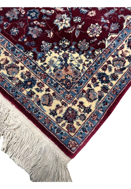 Edge view of a Persian Tabriz rug showing even finishing, crisp borders, tight weave structure, and consistent color definition along the rug perimeter