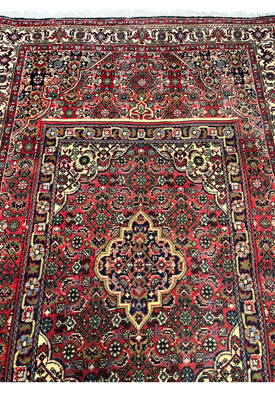 Central medallion detail of a Persian Bijar rug highlighting intricate geometry, ivory highlights, dark outlines, and dense iron-rug construction