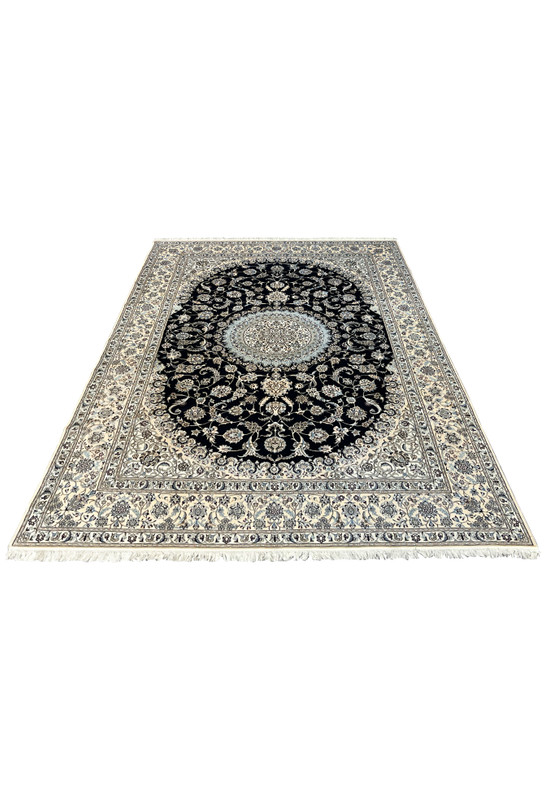 Angled view of a 7 x 10 Persian Nain 6 LA Habibian silk rug showing navy field, ivory borders, silk foundation, and balanced medallion design