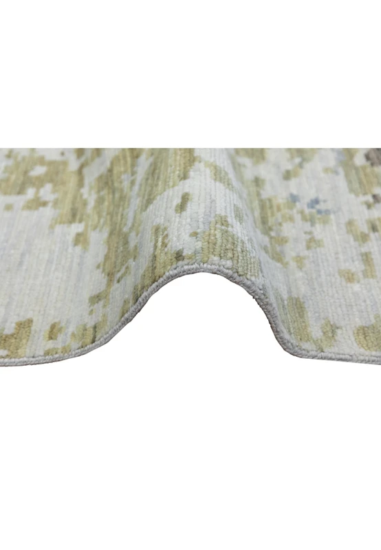 Side profile of a handmade Nepali wool rug displaying medium pile height, clean edge finish, and refined abstract color blending in blue and ivory tones.