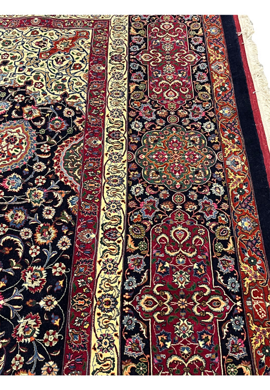 Persian Mashad rug colors and patterns with elaborate floral vines, medallion forms, and rich contrast between navy, red, ivory, and green hues.
