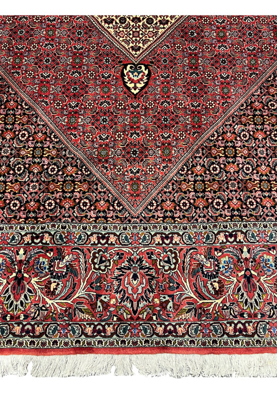 Lower border detail of a Persian Bijar iron rug featuring layered framing, floral-geometric motifs, dense weaving, and deep contrasting colors