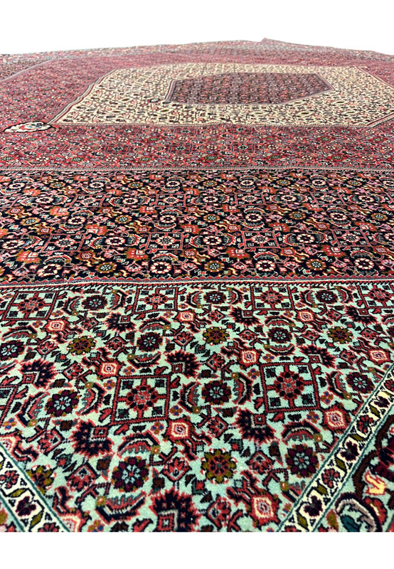 Detailed view of geometric motifs on a Persian Bijar iron rug with layered diamond patterns, rich red and navy palette, and exceptionally durable wool pile
