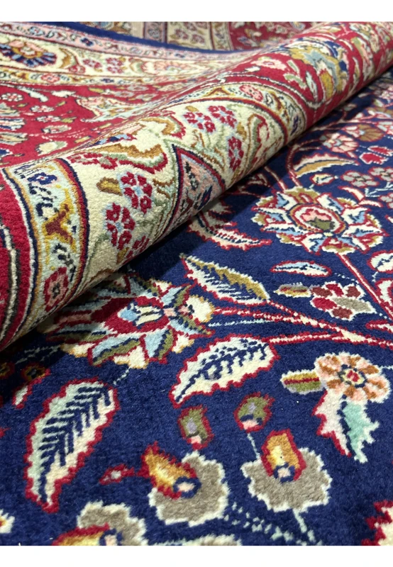 Rolled view of an 11'2 x 14'4 Persian Tabriz rug showing thickness, flexibility, and dense hand-knotted wool construction
