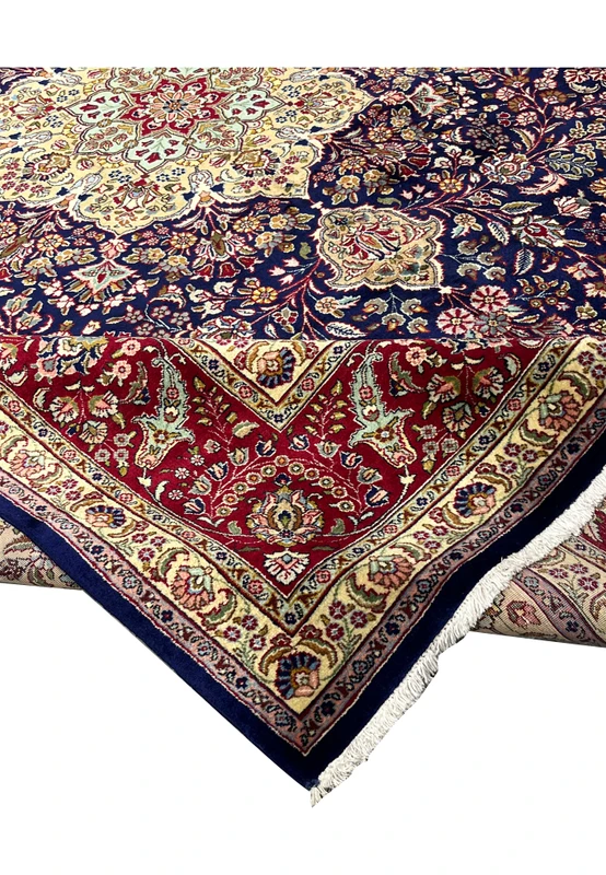 Folded edge view of an 11'2 x 14'4 Persian Tabriz rug showing deep navy field, ivory border details, tight pile, and refined floral motifs