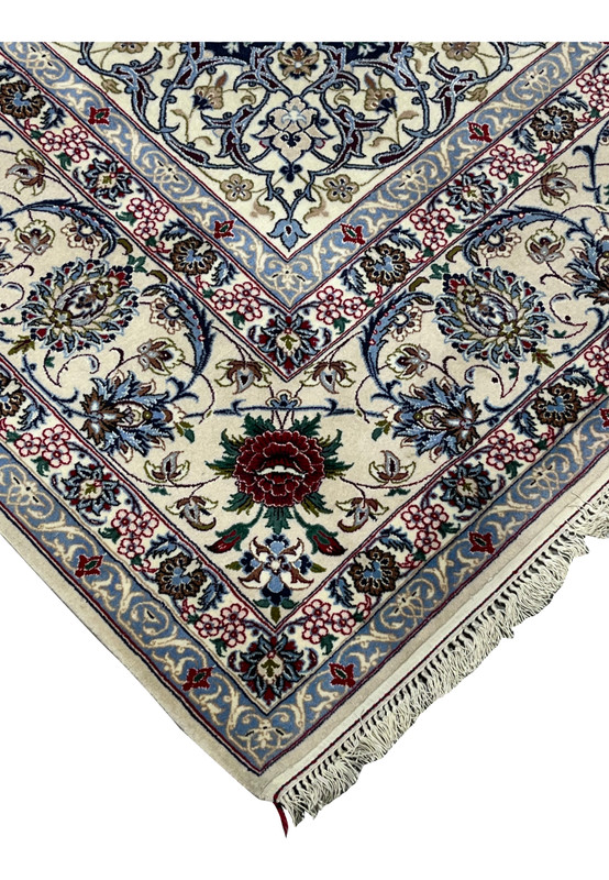 Angled side view of a Persian Isfahan rug emphasizing the plush wool pile, silk accents, navy ground, and finely articulated floral design