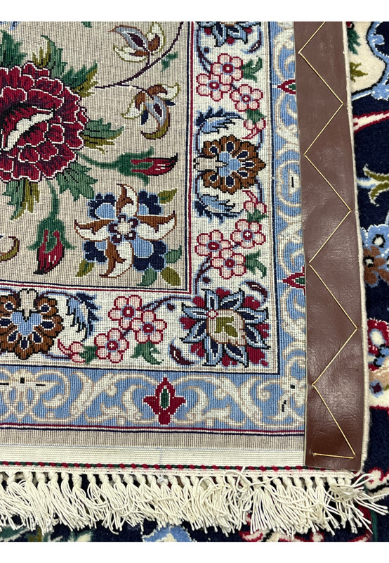 Backside of a 7x10 Persian Isfahan rug showing tight knot structure, silk accents, fine weave, and precise craftsmanship