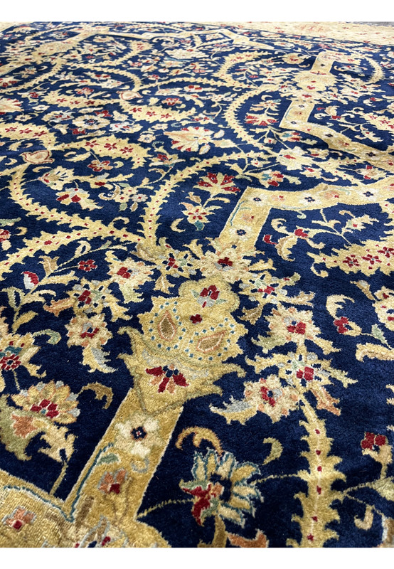 Close-up of the field in a distressed Indian Agra rug showing floral detailing, faded navy wool, gentle color variation, and authentic wear patterns