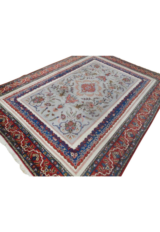 Angled view of an 8'10 x 11'9 Persian Isfahan rug with rare grey field, floral medallion, red and blue accents, and layered decorative borders