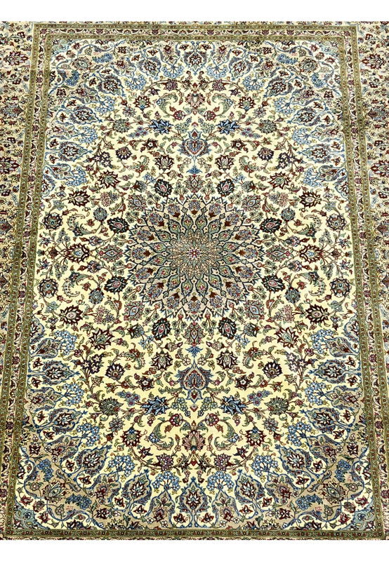 Midfield detail of a signed Persian Qum pure silk rug revealing dense floral motifs, flowing vine patterns, and crisp color transitions on an ivory background.