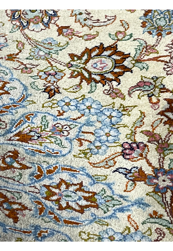 Extreme close-up of silk pile on a Persian Qum rug revealing luminous silk fibers, dense knot structure, and high-definition floral pattern clarity.
