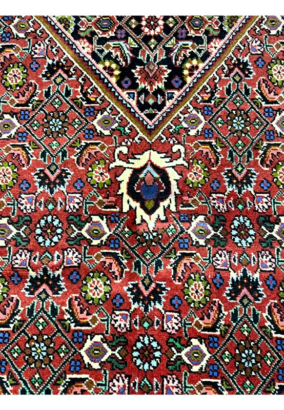Color close-up of Persian Bijar rug highlighting brick red, ivory, olive, blue, and black wool tones with crisp contrast and sharp definition