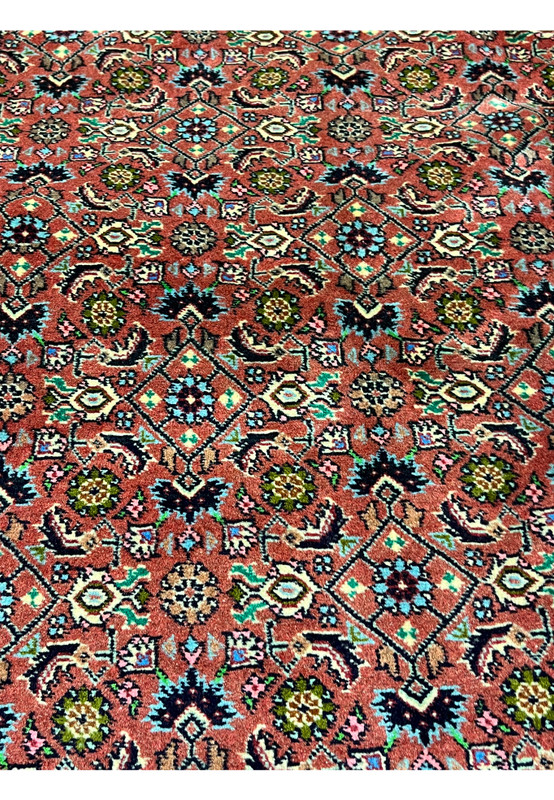 Close-up of Persian Bijar rug motifs featuring stylized flowers, diamond shapes, and classic craftsmanship