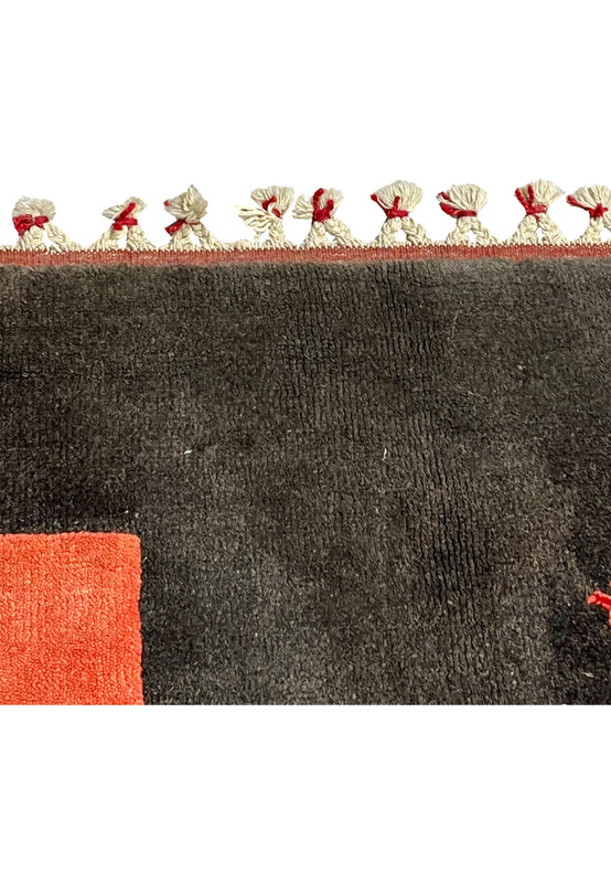 Fringe detail of Persian Gabbeh rug showing hand-tied tassels with red and blue accents and sturdy cotton foundation
