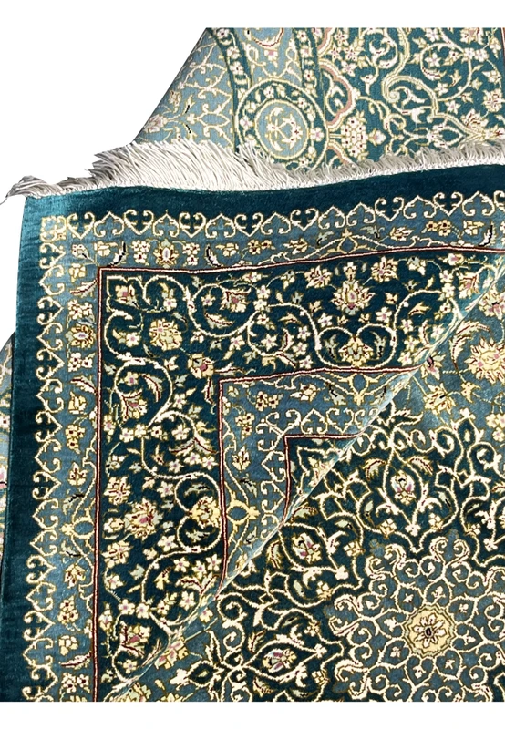 Folded edge detail of silk handmade rug showing clean backing, tight knots and crisp floral pattern alignment along border