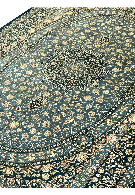 Angled perspective of signed Darakhshan silk rug highlighting oval medallion, intricate floral field and reflective silk sheen under light