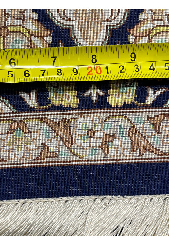 Back of rug with measuring tape showing compact knot density and precision weaving scale emphasizing ultra fine Persian silk craftsmanship.