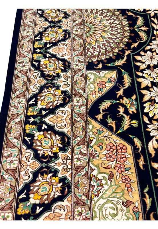 Close-up of ornate floral border with camel, ivory, gold and teal accents framed by navy guard stripes in high density Persian silk knots.