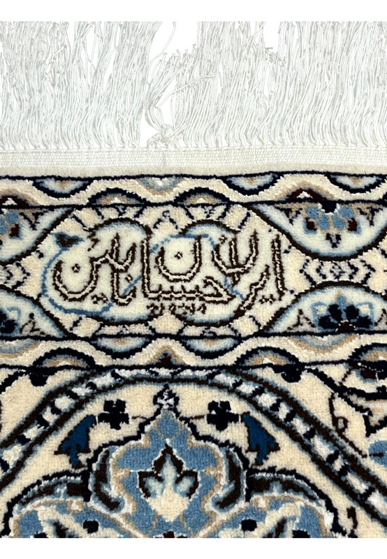 Habibian signature woven into ivory border of Persian Nain 6 LA rug with navy and light blue detailing.